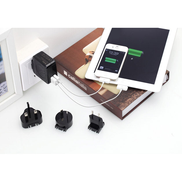 Phone charging station with multiple plug adapters on a white surface