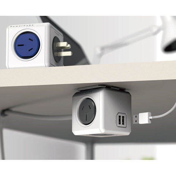 Cube-shaped power strip with multiple outlets and USB ports on a desk.
