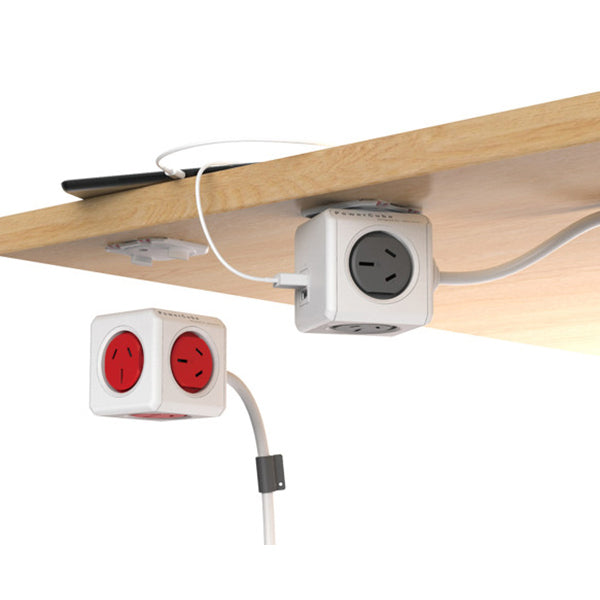 Two power outlets with cables attached underneath a wooden shelf on a white background