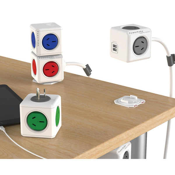 Cube-shaped power outlets with different color sockets on a wooden surface