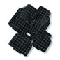 Set of four black car mats with a textured pattern on a white background