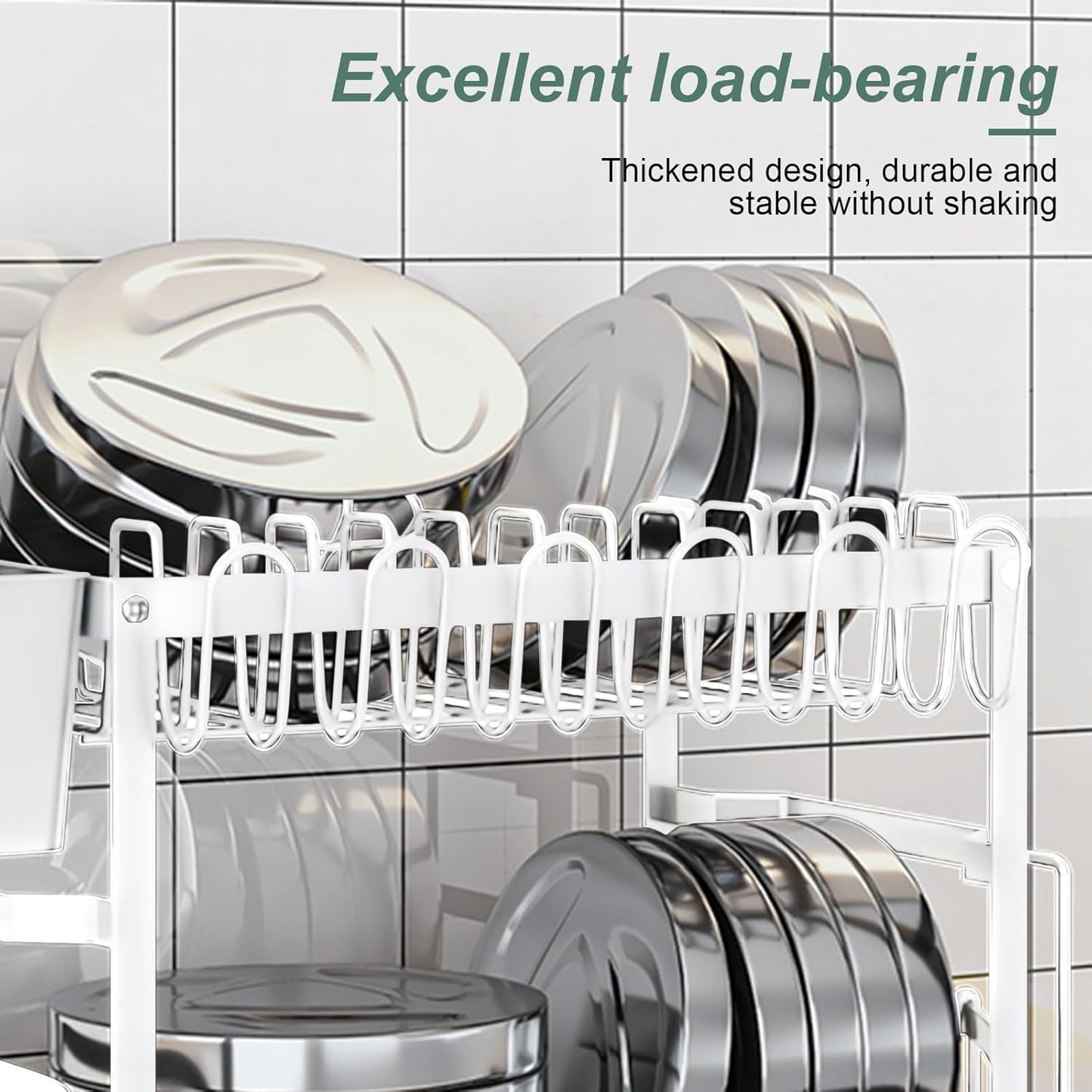 Dish rack with silver dishes on a tiled wall background