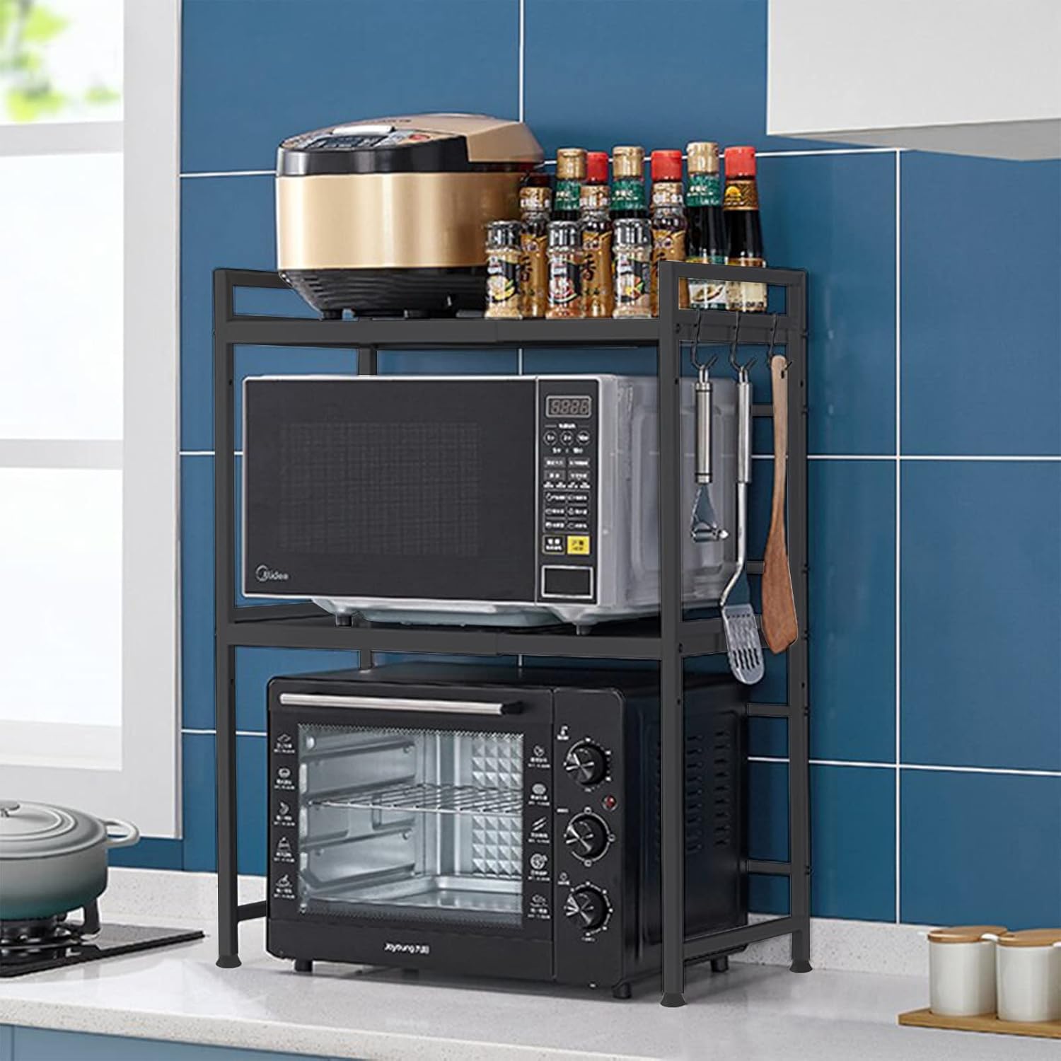 Kitchen shelf with microwave, toaster oven, and various kitchen items against a blue tiled wall.
