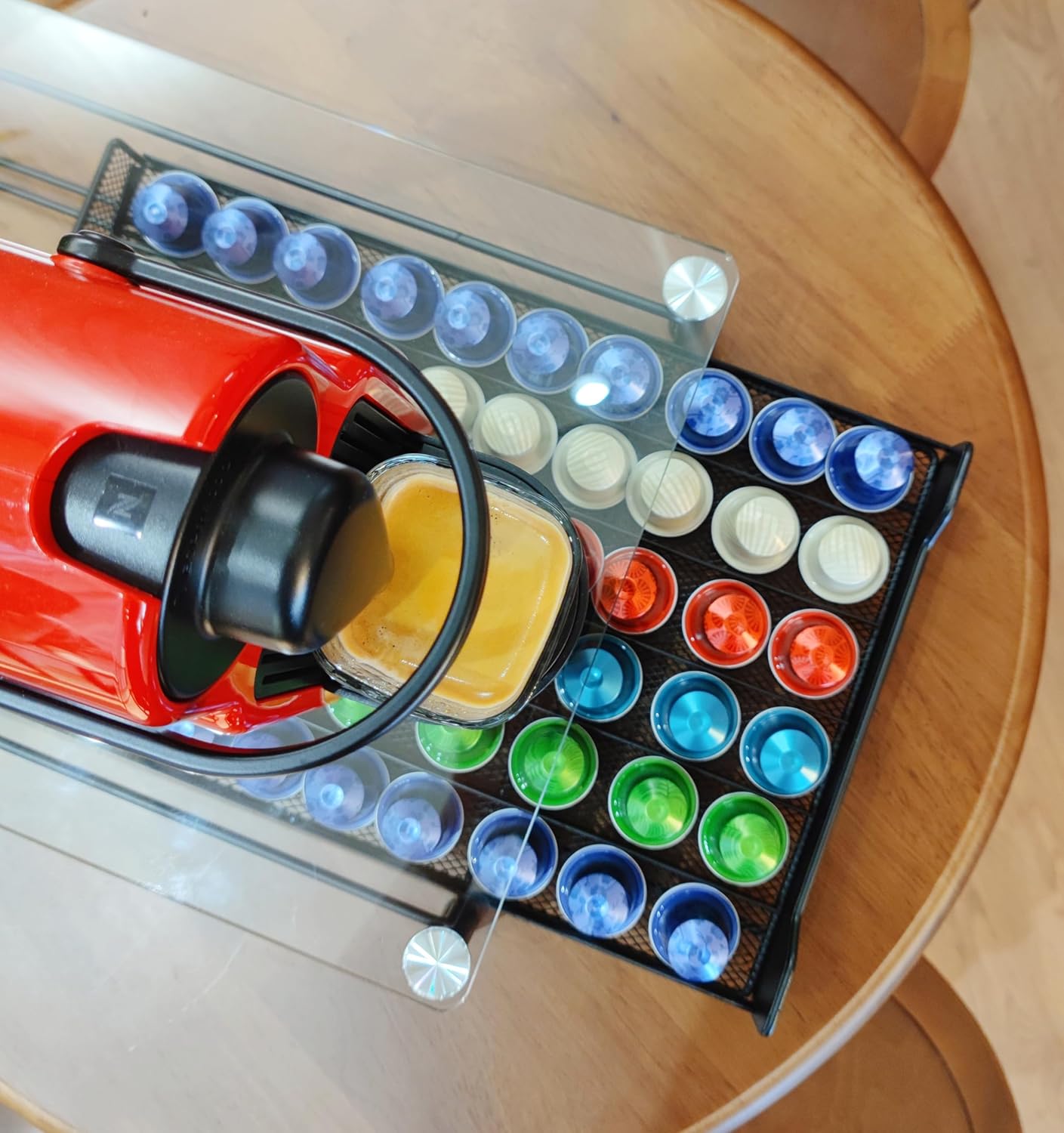 Red coffee machine with colorful coffee pods on a wooden table