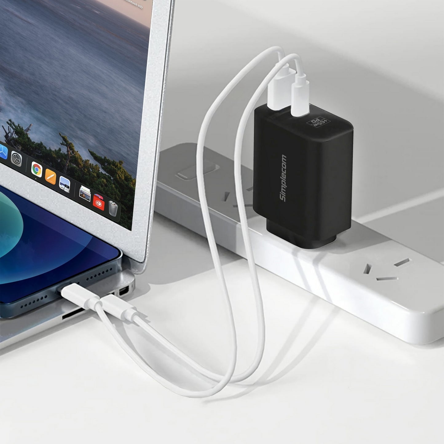 Black USB-C adapter connected to a laptop with a white cable on a light gray surface.