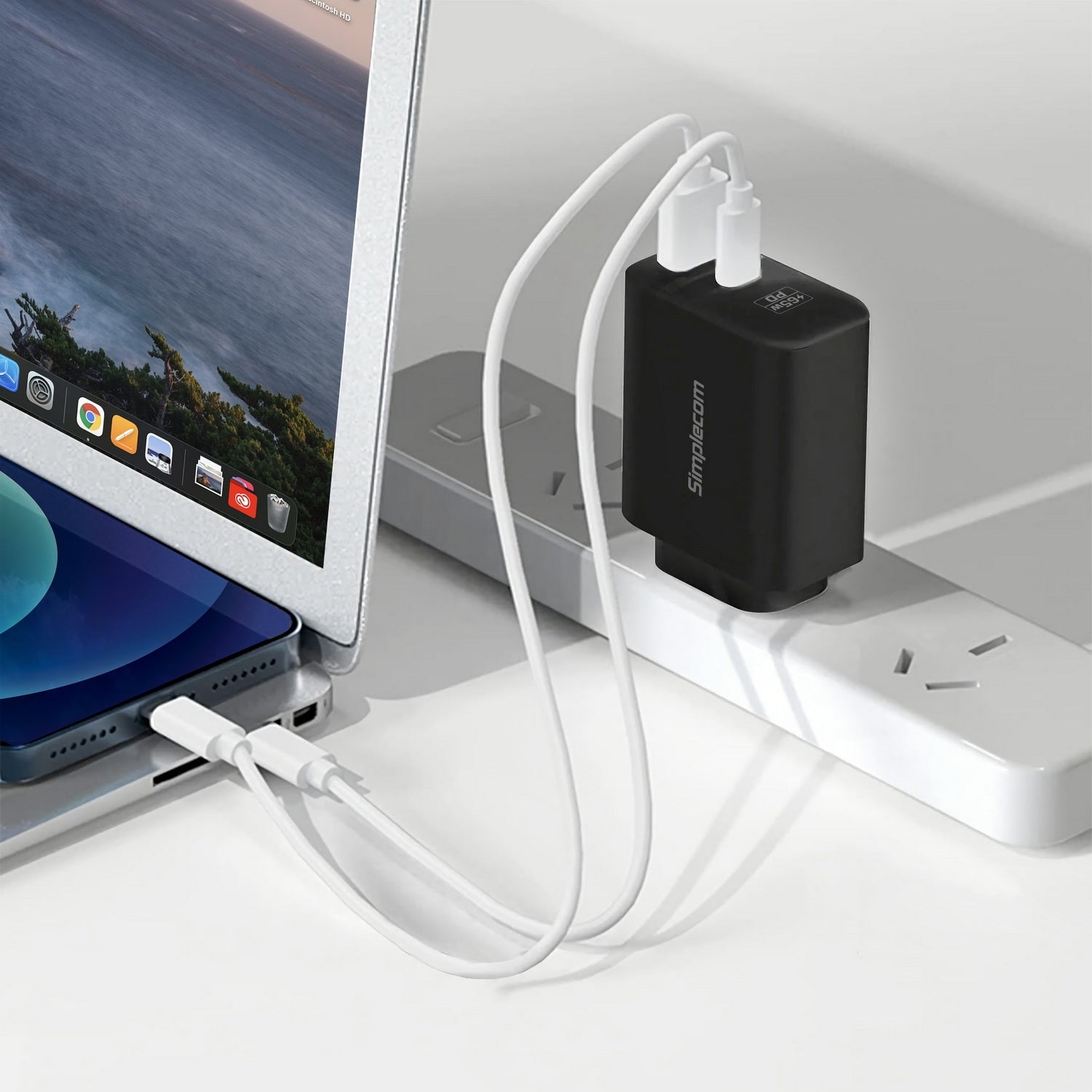 Black USB-C adapter connected to a laptop with a white cable on a light gray surface.
