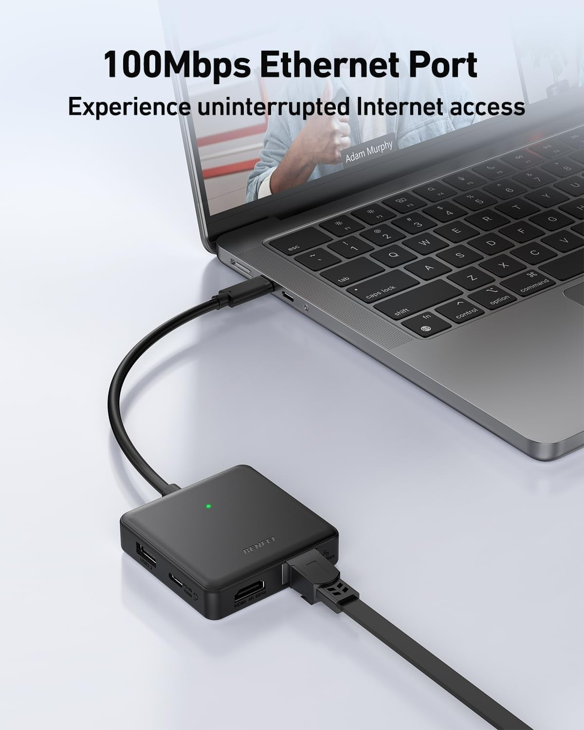 Laptop with Ethernet adapter on a white surface, emphasizing 100Mbps Ethernet Port feature.