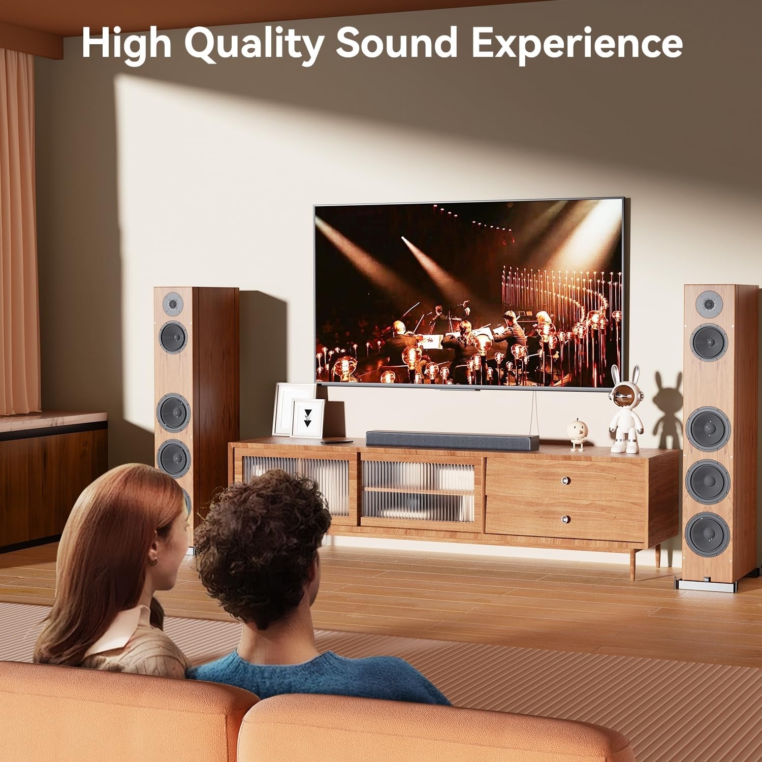 Couple watching a concert on a large TV with surround sound speakers in a living room.