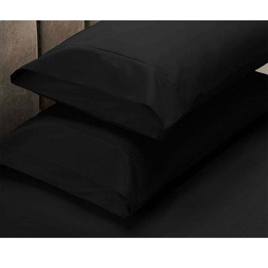 Black pillowcases on a bed with a neutral background